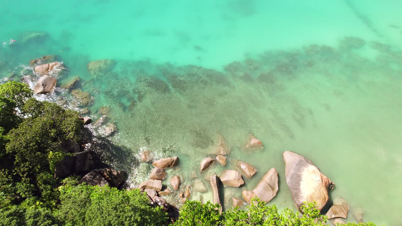Riprese con drone di pietre di granito vicino alla spiaggia, circondate da alberi, acqua turchese, Anse Louis, Mahe Seychelles 30 fps