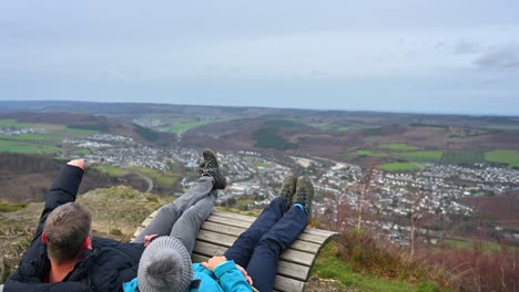 años dorados en sauerland: una pareja de ancianos descansando en un banco y disfrutando de la vista panorámica de la ciudad de olsberg en un día nublado de invierno