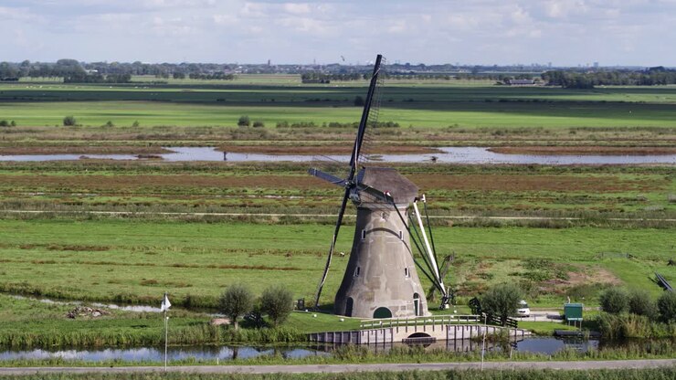 Ripresa aerea in parallasse di un tipico e iconico mulino a vento olandese ad Haastrecht.