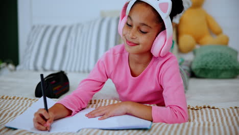 girl with headphones writing in a journal