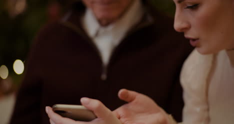 Woman-Teaching-Grandfather-To-Use-Smartphone-In-Christmas-3