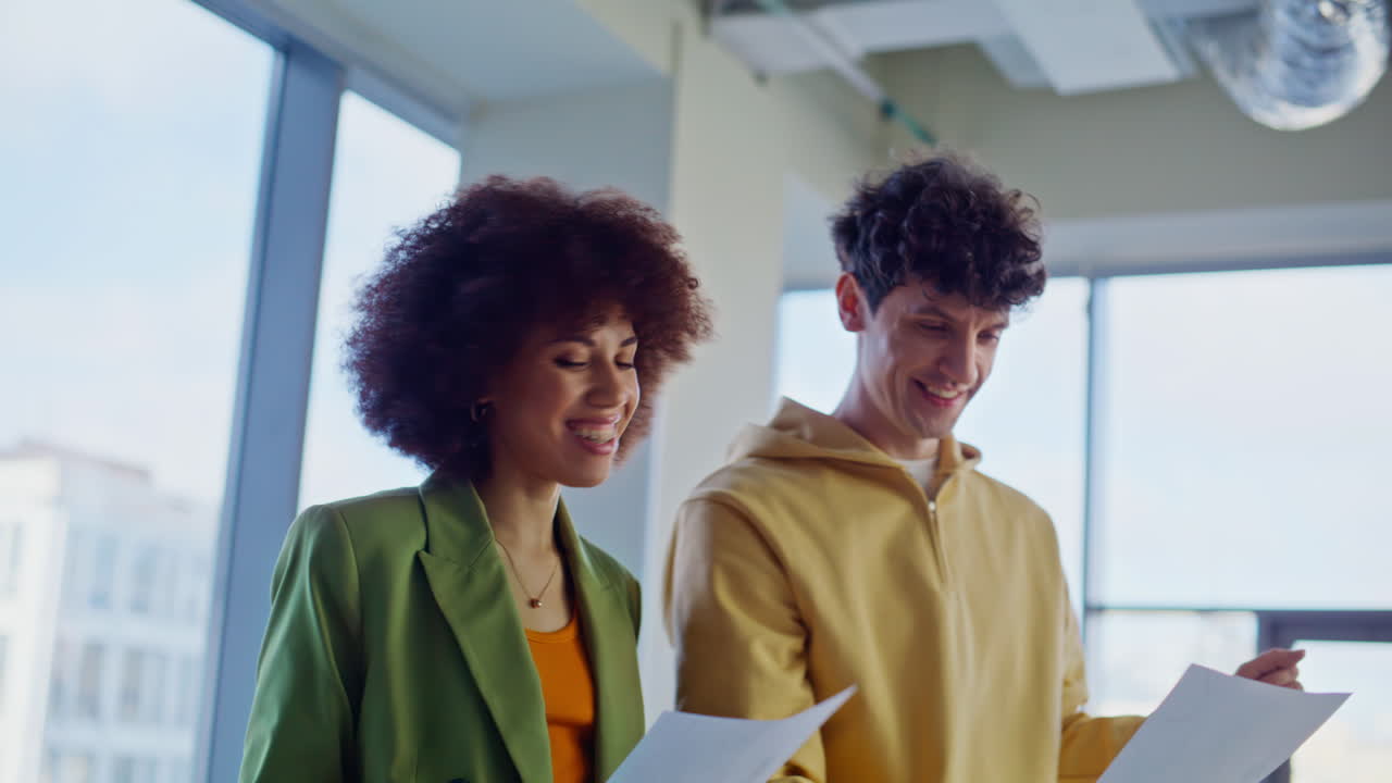 Creative managers watching papers enjoying successful teamwork in office closeup