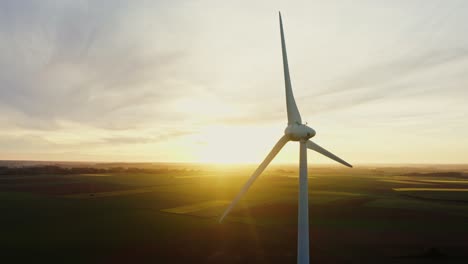 wind turbine at sunset over farmland
