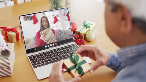 biracial man with gift having laptop video call with happy biracial woman