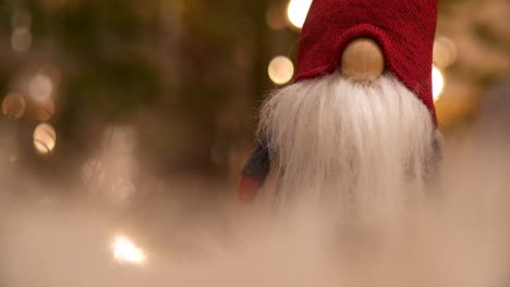 santa claus gnome with blurry christmas tree in a dreamy christmas scene, close up