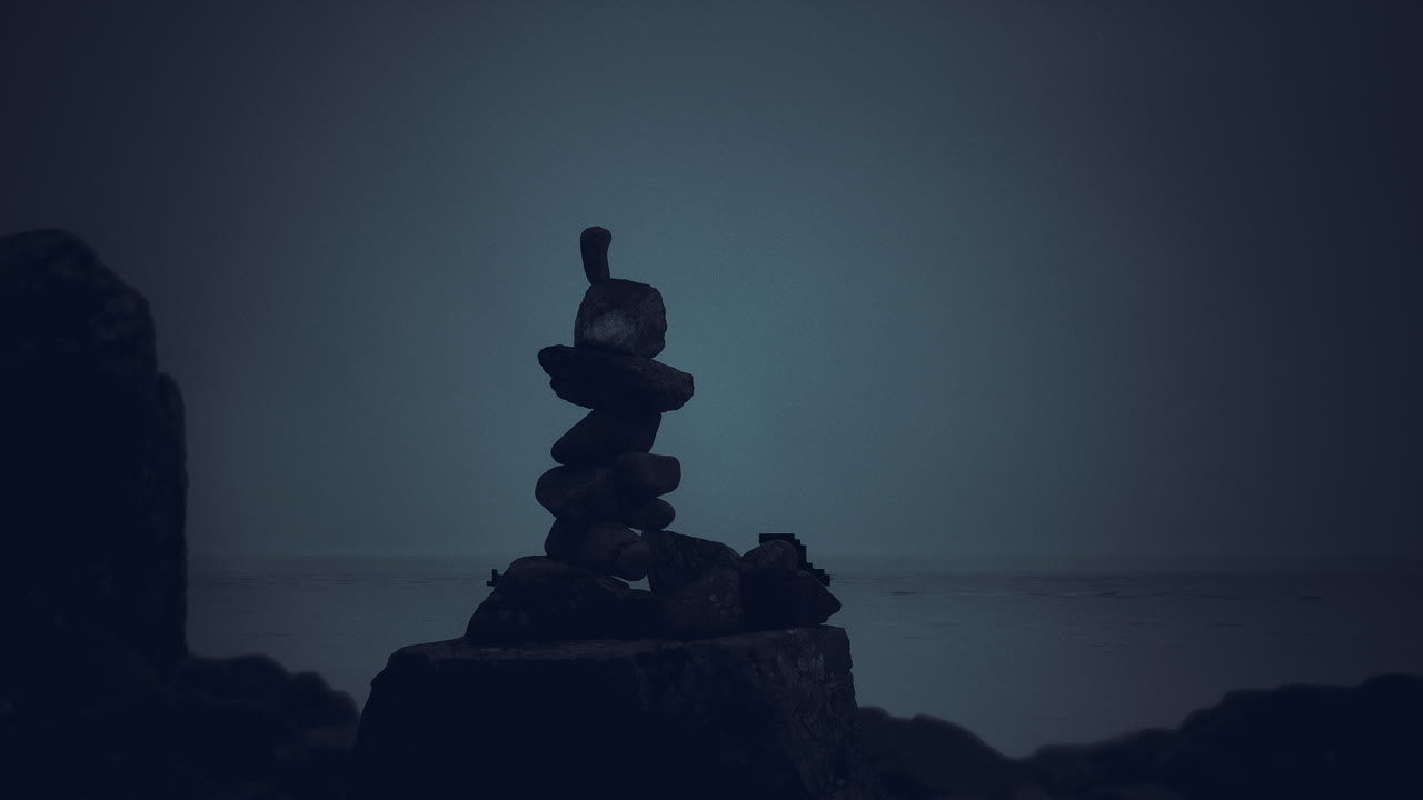 Stacked stones create a serene monument at the water edge during twilight
