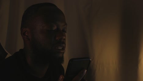 hombre negro en una acalorada conversación por teléfono en la oficina de casa