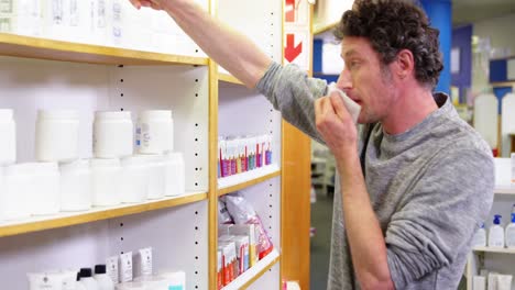 customer checking medicine box while sneezing