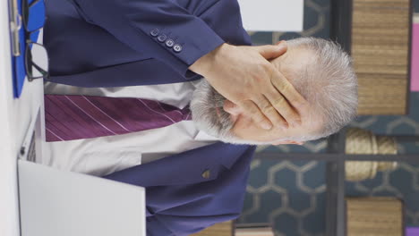 Vertical-video-of-Sleepy-old-businessman-yawns-looking-at-camera.