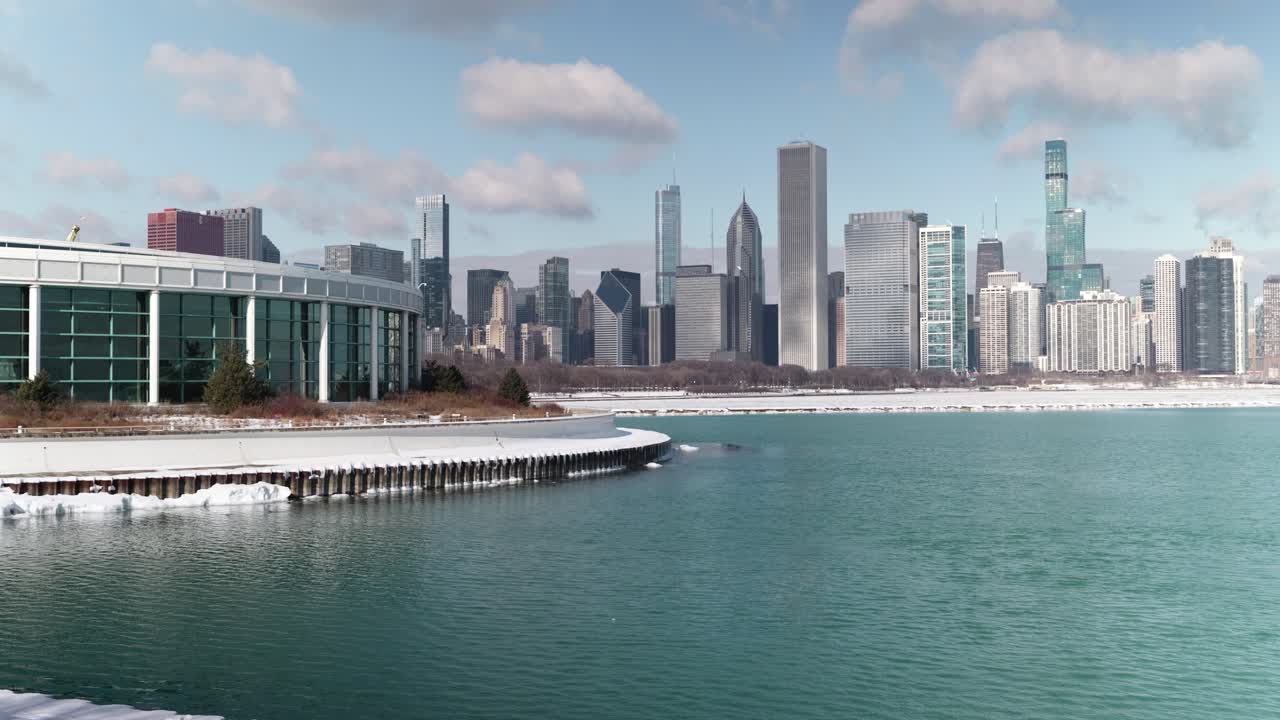 Shedd Aquarium building exterior against Chicago city skyline and Lake Michigan in winter