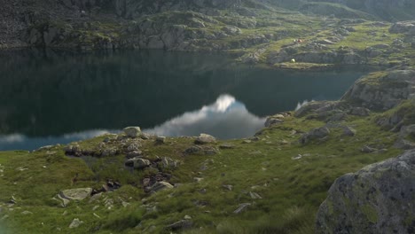 Scenic-reflection-of-mountains-and-clouds-in-small-lake-in-Italy