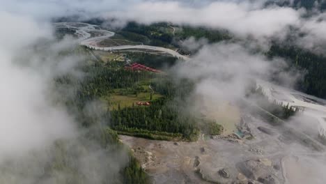 Beautiful-drone-shot-flying-through-clouds-over-forest-and-mountains