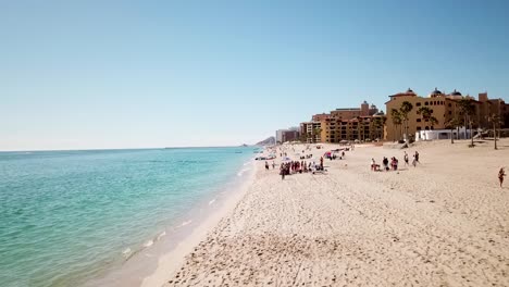 Drone-shot-of-tourists-relaxing-on-a-warm-beach-in-Mexico