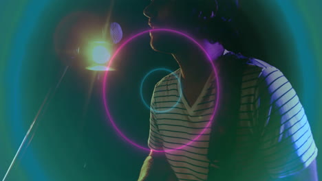 singer performing into microphone on dark stage, surrounding neon flares animating music technology