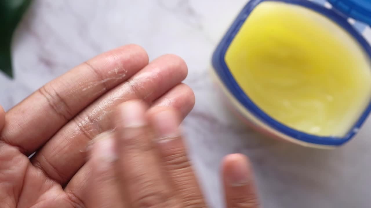 Aplicando vaselina o crema hidratante en las manos