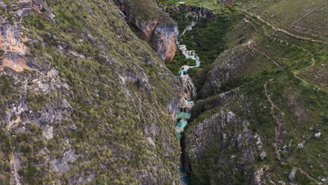 amazing aerial zoom out shot with drone from the andes area in ayacucho peru, of the famous turquoise lake millpu located between mountains