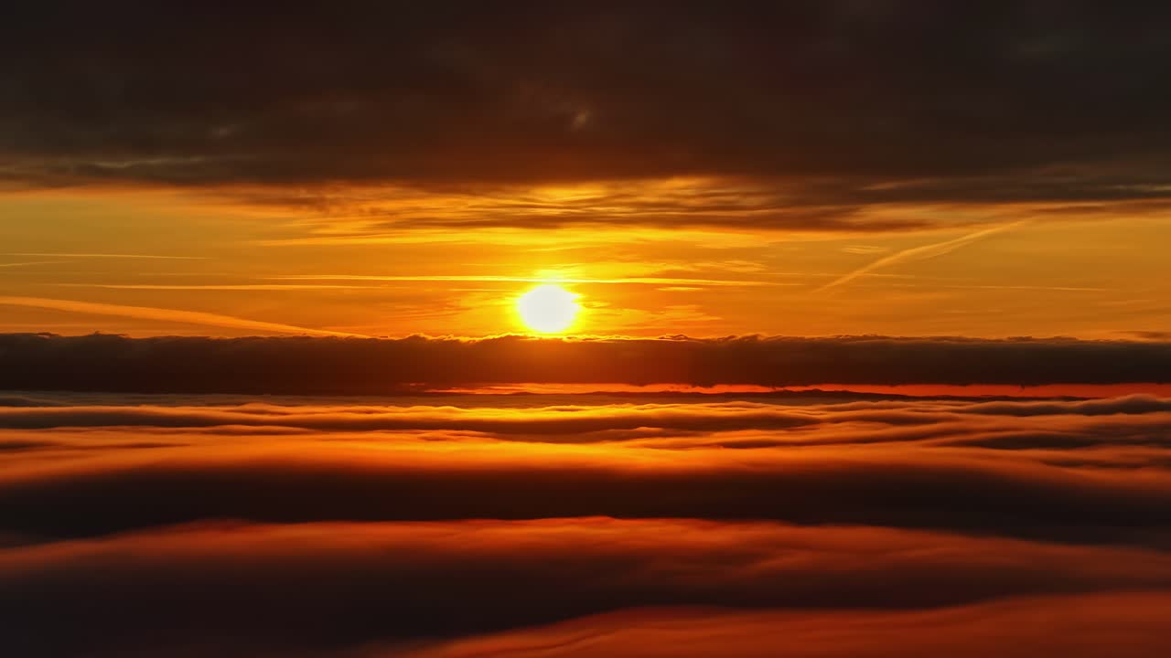 Panoramasonnenuntergang über den Wolken mit goldenem Himmel zur Blauen Stunde, Skyline mit baumwollartiger Wolkentextur im Hintergrund als Naturkulisse.