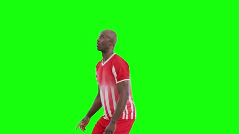 Video-of-african-american-male-soccer-player-kicking-ball-on-green-screen-background