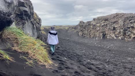 woman peacefully walking between north america and eurasia tectonic plates in iceland