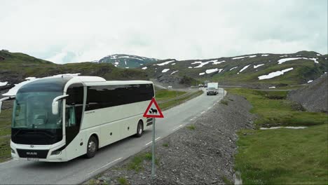 Tourist-bus-passing-Sheep-warning-sign-on-top-of-Norwegian-mountain-pass