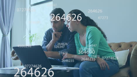 múltiples números cambiantes flotando sobre una pareja caucásica calculando las finanzas juntos en casa