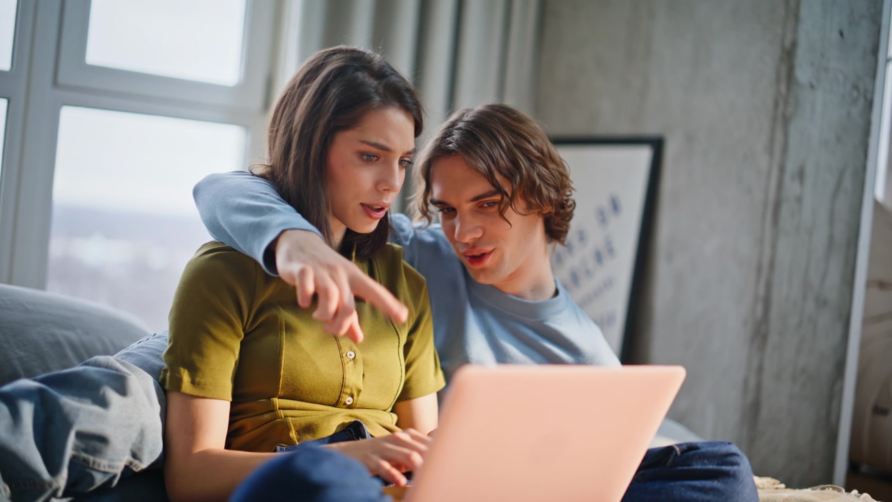 Emotional lovers using computer cuddling at bedroom closeup. Enamoured couple