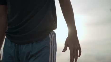 a man walking during a sunset, engaged in exercise, highlighting the beauty of an evening workout and physical well-being