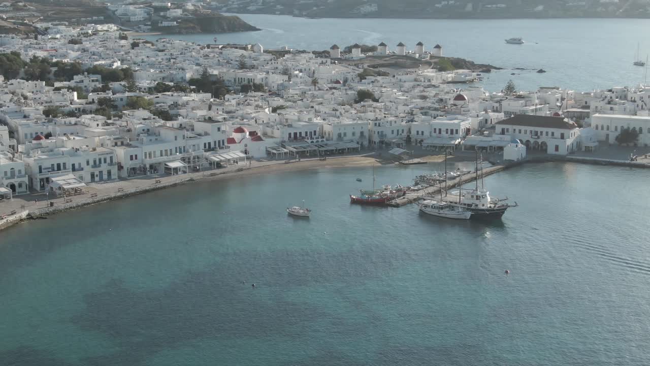 clip de drone 4k de la ciudad de mykonos que destaca el puerto antiguo, el área de matoyianni y los famosos molinos de viento en el fondo