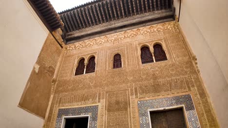 panoramic and detail shot of the comares facade facing the gallery of the golden room, marking the division between the public and private areas of the alhambra monumental complex in granada, spain