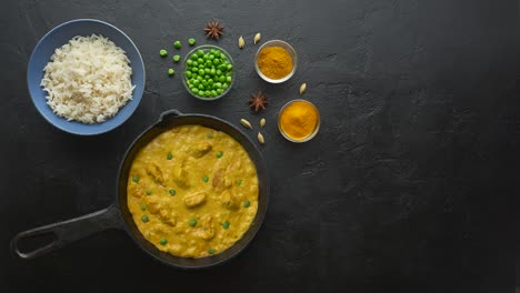 cinemagraph loop. cooking tasty chicken curry in pan with spices. flat lay, top view with copy space