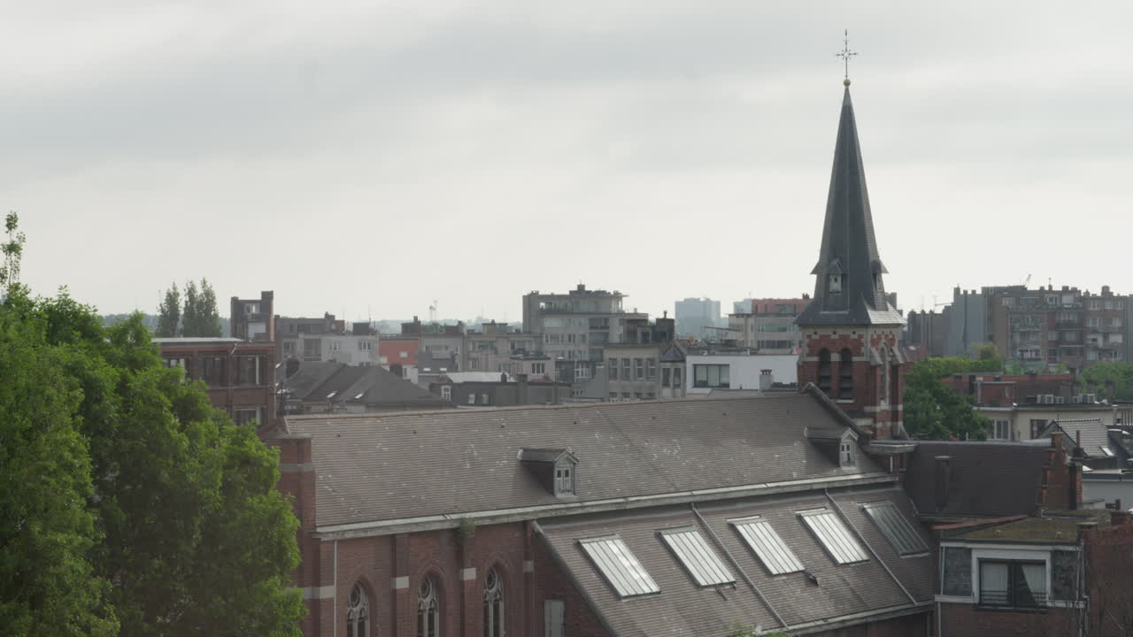 Une vue panoramique diurne sur les toits d'Anvers, Belgique, avec une église historique proéminente au premier plan. Capturée depuis une perspective élevée.