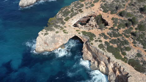 rock cliffs above sea waves with arches formed due to water erosion