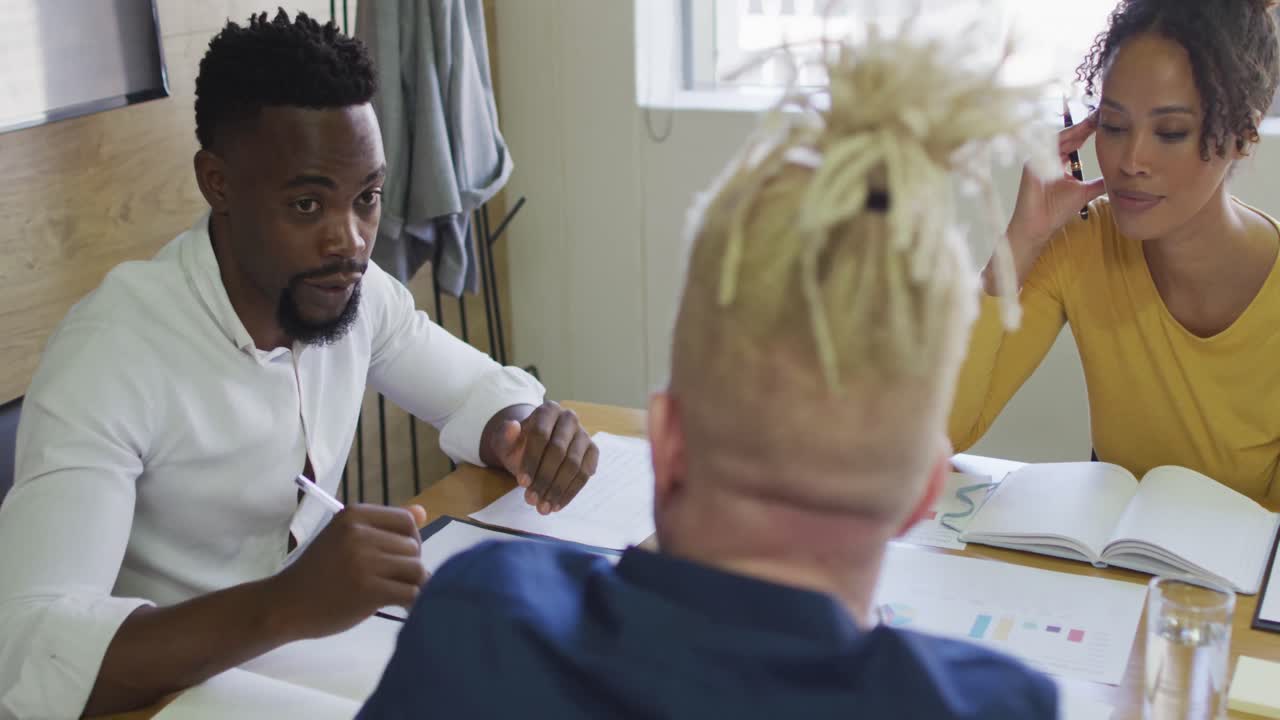 diversas personas de negocios discutiendo con documentos en una reunión en la oficina creativa