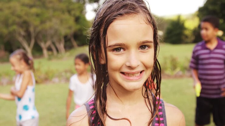 Retrato de menina sorrindo no jardim.
