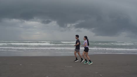 pareja corriendo en la playa
