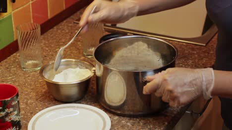 spooning flour into a saucepan to make a dessert icing