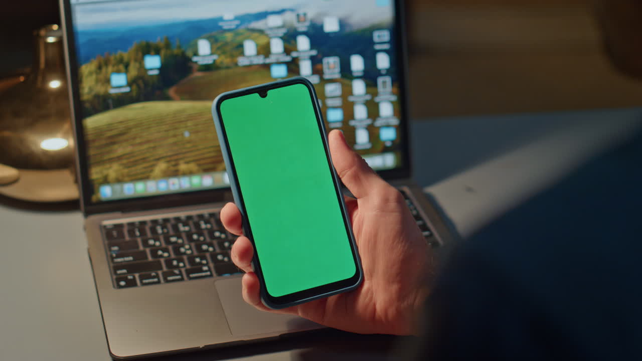Man finger touching green phone screen indoor closeup. Guy scrolling smartphone