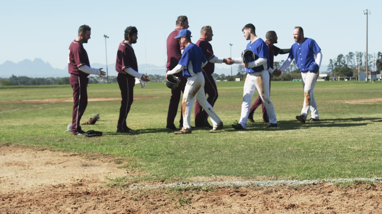 Multiracial male baseball players and shaking hands with each other on a pitch, slow motion