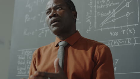 professor lecturing in front of a blackboard