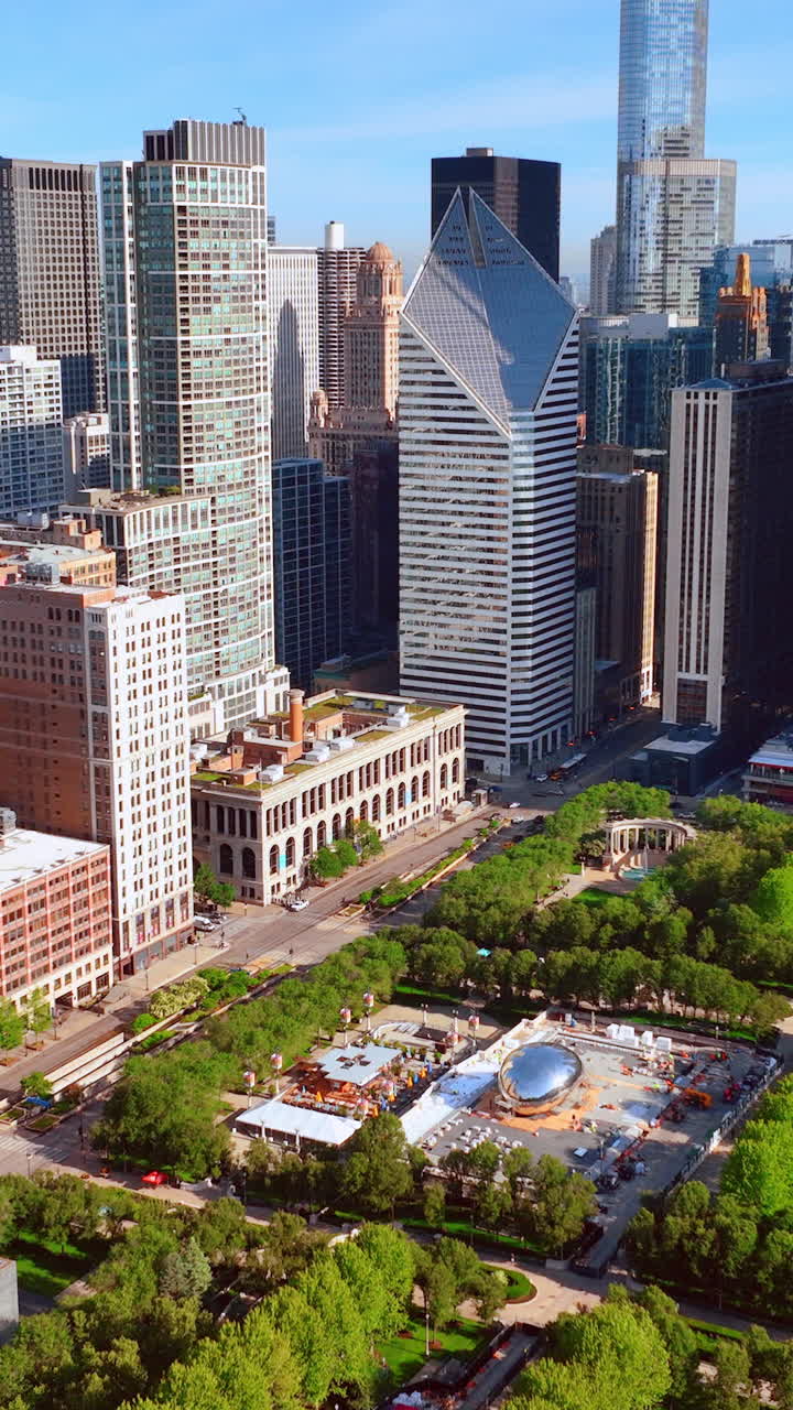 Artistic commemoration of the famous shiny bean sculpture in the center of a Chicago park. Aerial view of the city with trees and skyscrapers. Vertical video