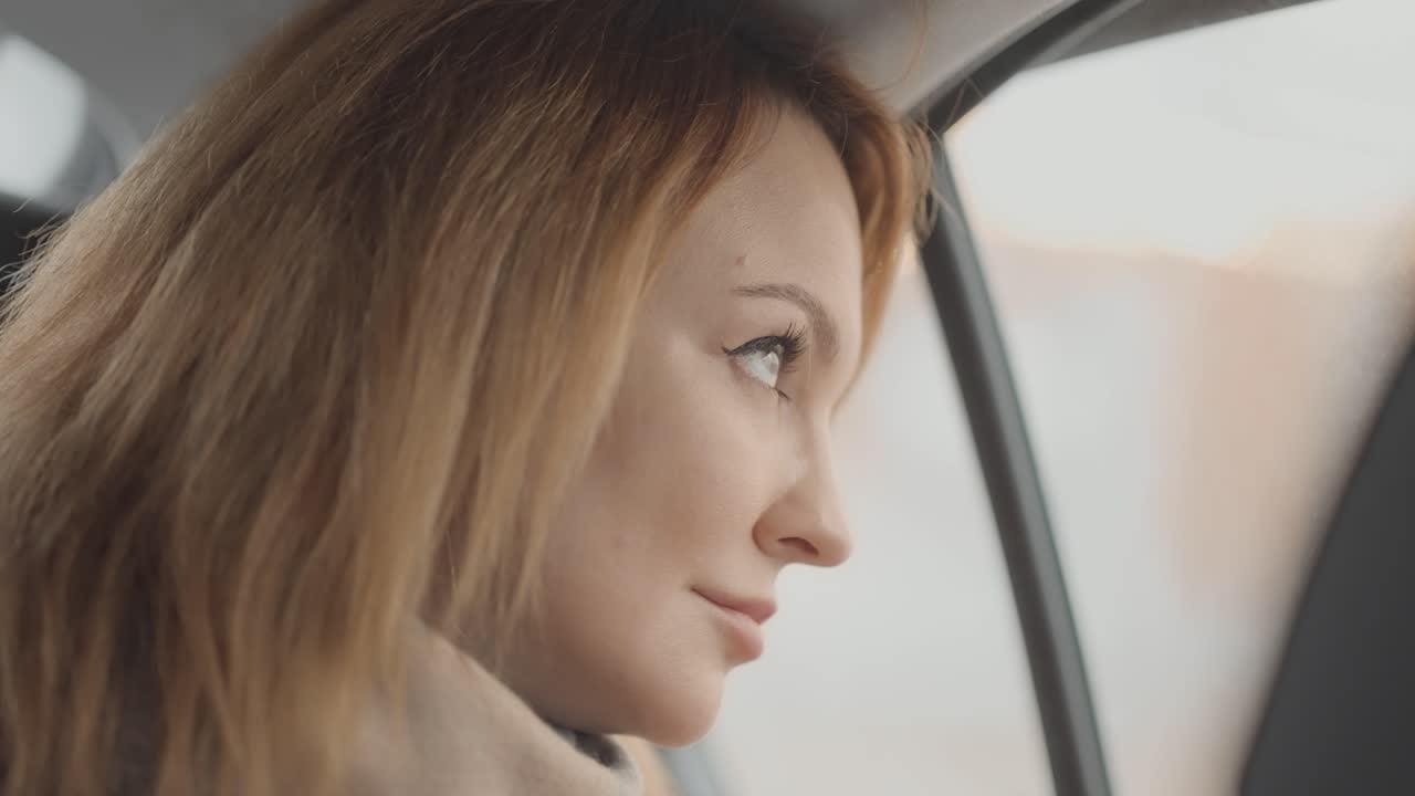 Mulher olhando pela janela do carro