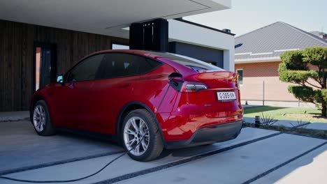 red electric car charging at home