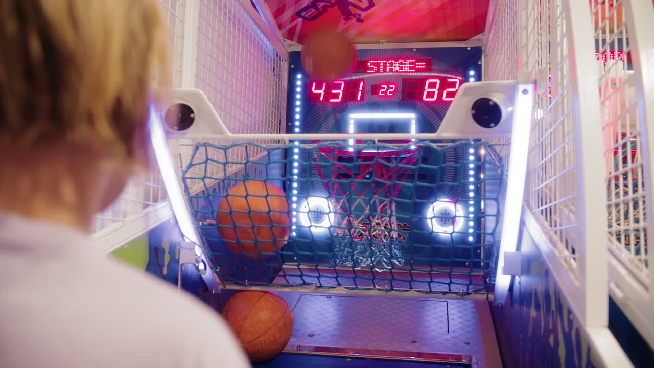 Adolescente al gioco di basket della sala giochi