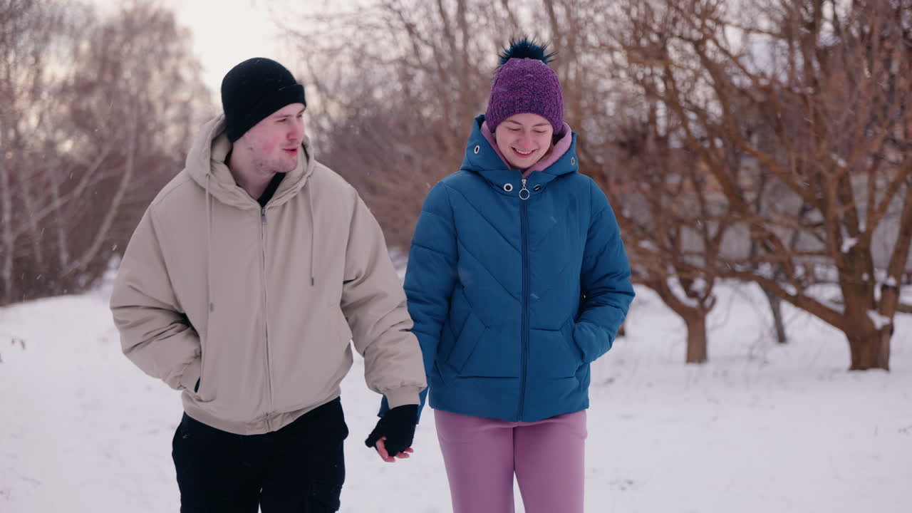 pareja caminando de la mano en la nieve