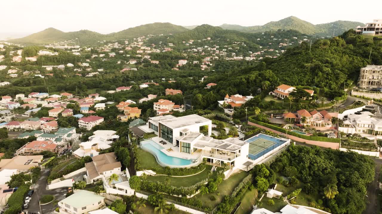 Drone view of a luxury area in Rodney Bay St. Lucia with a mansion on the hill with a pool and tennis court