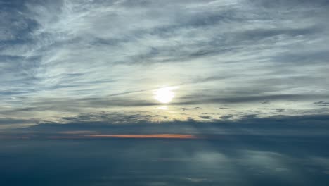 awesome aerial view from a jet cockpit of a beautiful sky with the solar disc vealed after some stratus clouds during sunset