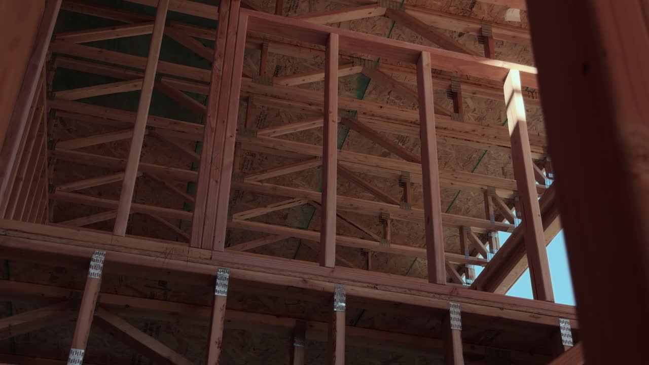 Smooth upward interior glide showing trusses and framing inside new residential build