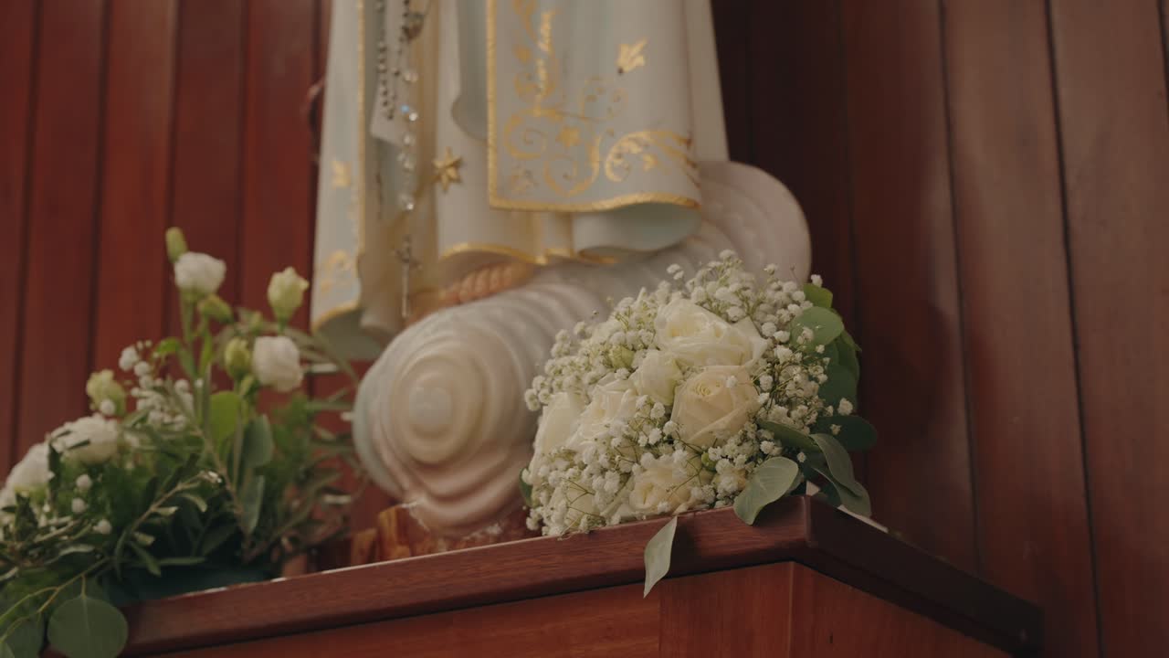教会の祭壇にある聖母マリア像の足元に飾られた白い花