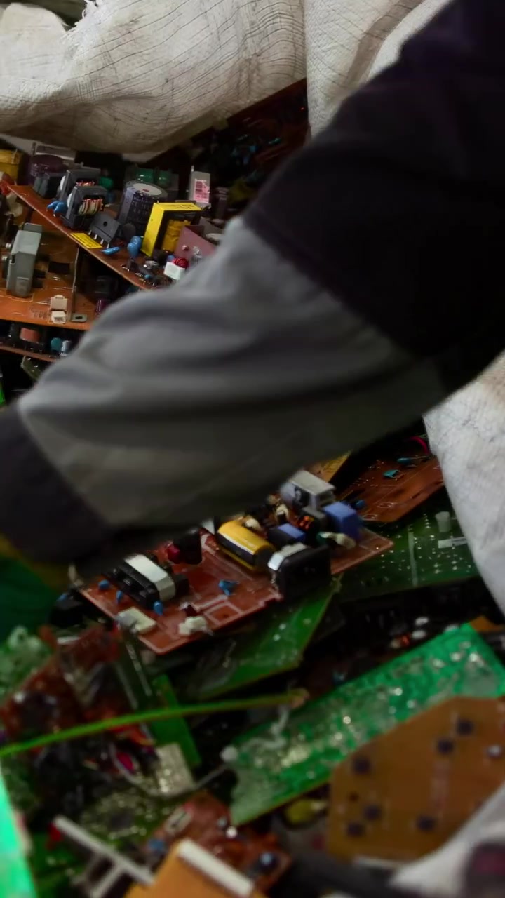 Gloved Worker Hands Sorting Circuit Boards Inside Recycling Workshop, Closeup Of Manual Inspection