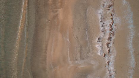 Lake-Huron-at-sunset-with-gentle-waves-lapping-the-sandy-shore,-aerial-view